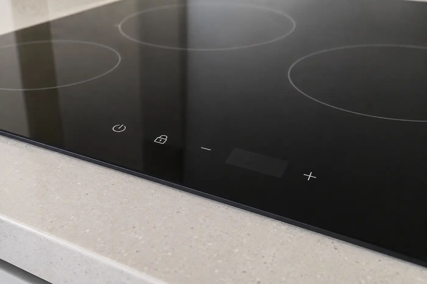 Modern black glass cooktop with a simple unlit touch control panel