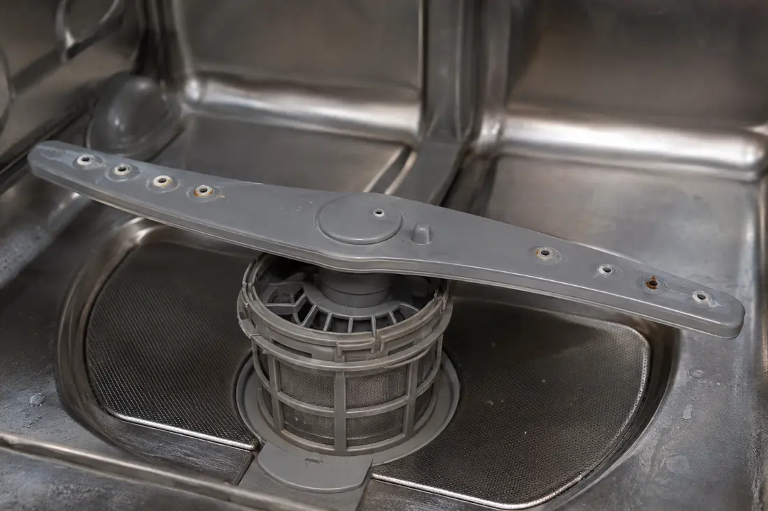 Dishwasher lower spray arm with restricted spray holes