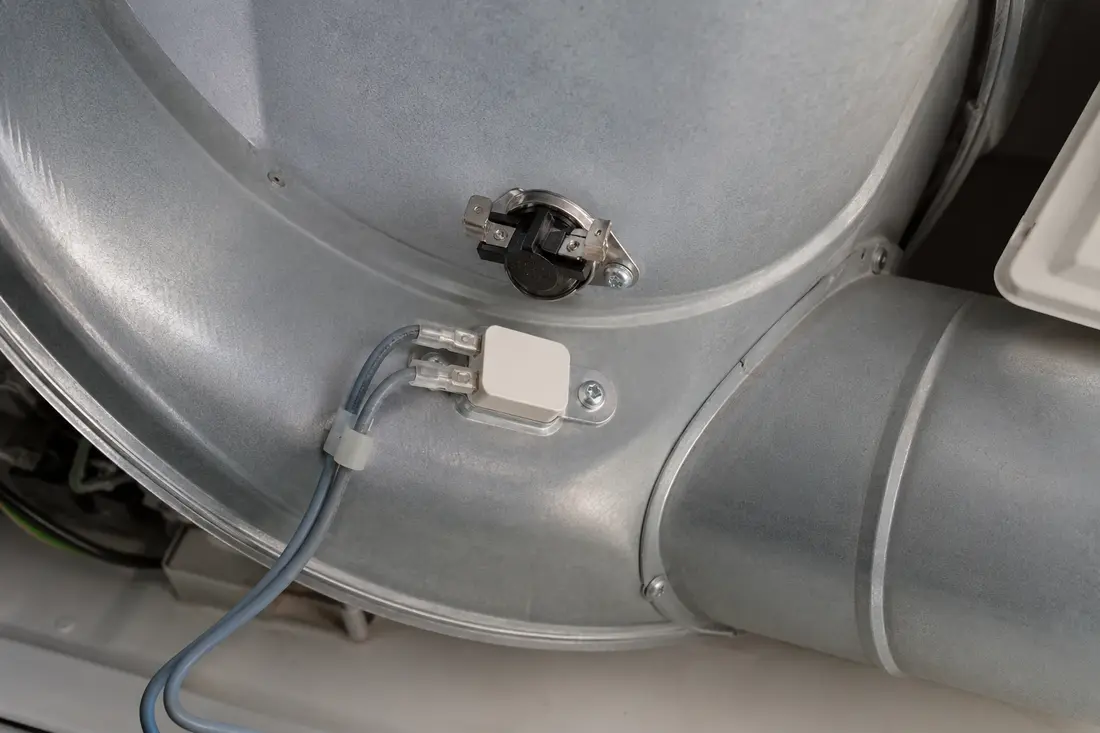 Dryer thermal fuse and thermostat mounted on the blower housing