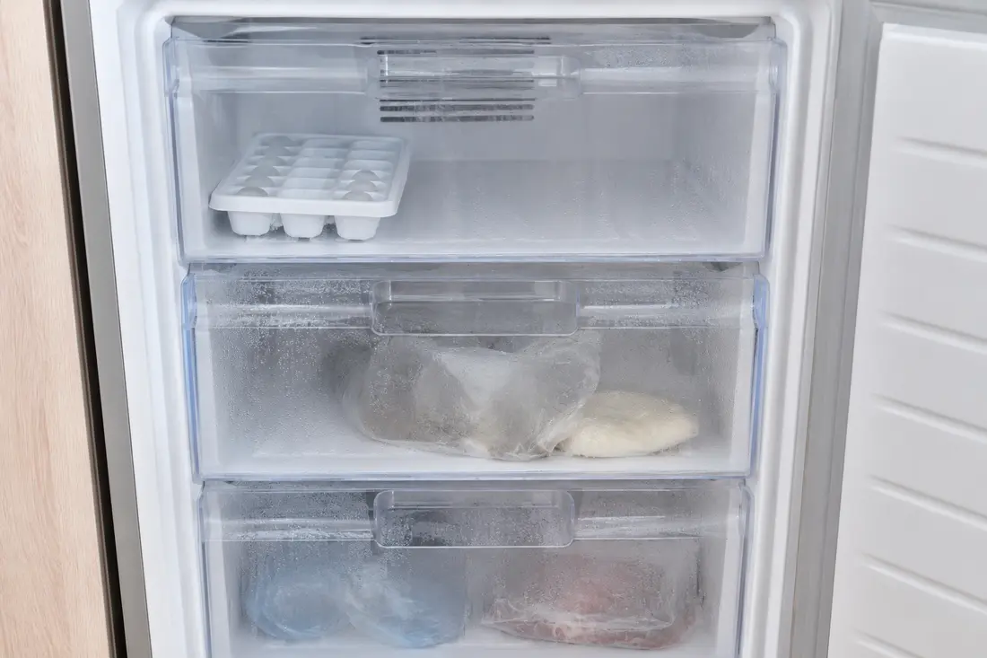 Freezer drawers with condensation and partially melted ice cubes
