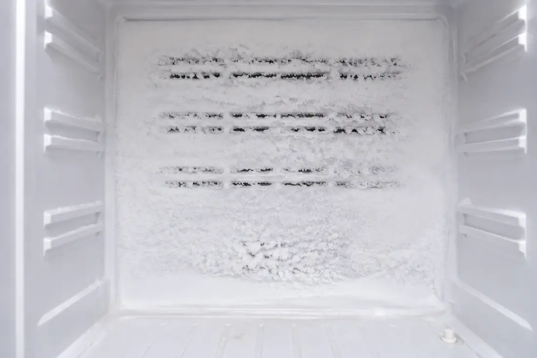 Heavy white frost covering the rear air vents inside a freezer
