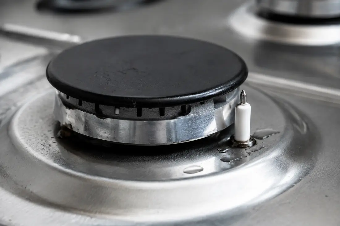 Gas range burner and ceramic igniter with moisture around the burner base