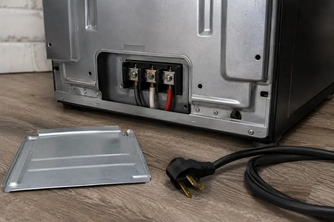 Rear electric range terminal block with mild heat discoloration at one lug