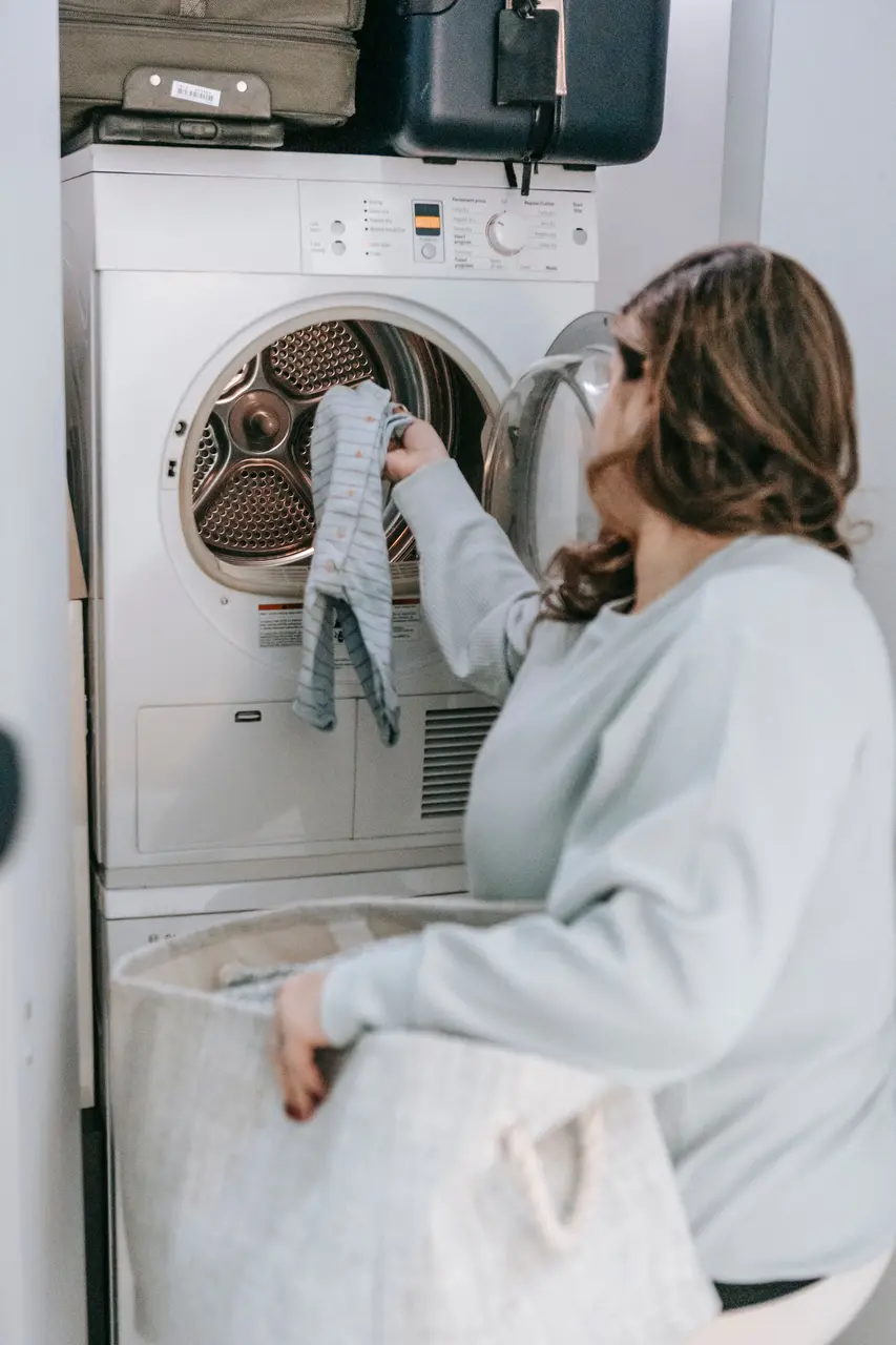 Homeowner checking clothes at an open dryer